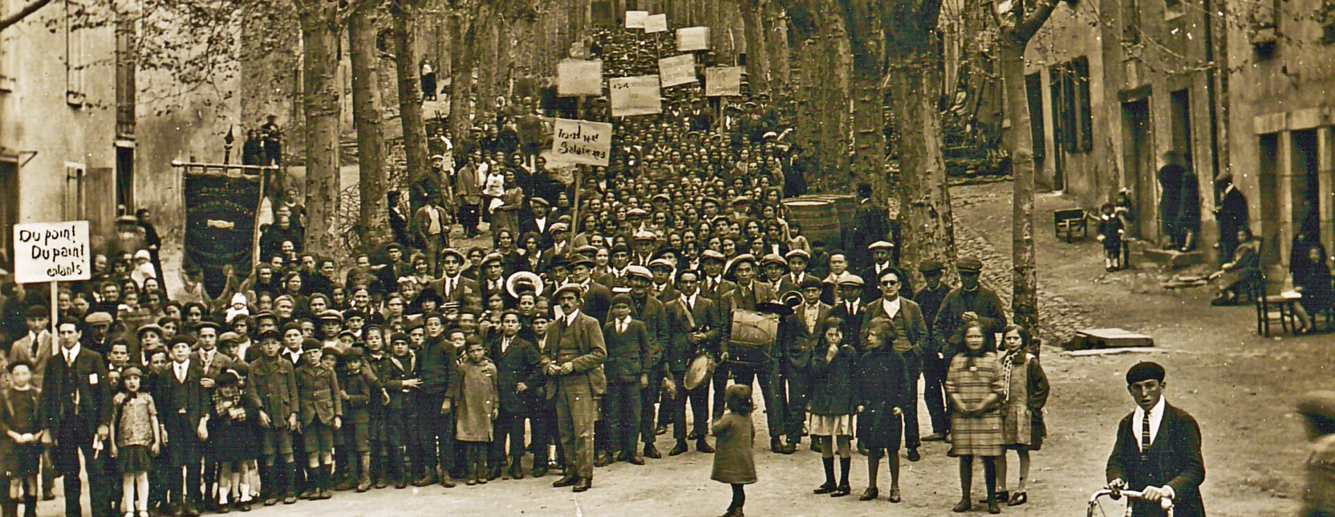 Carte postale représentant la horde de grévistes, dont certains tiennent des pancartes